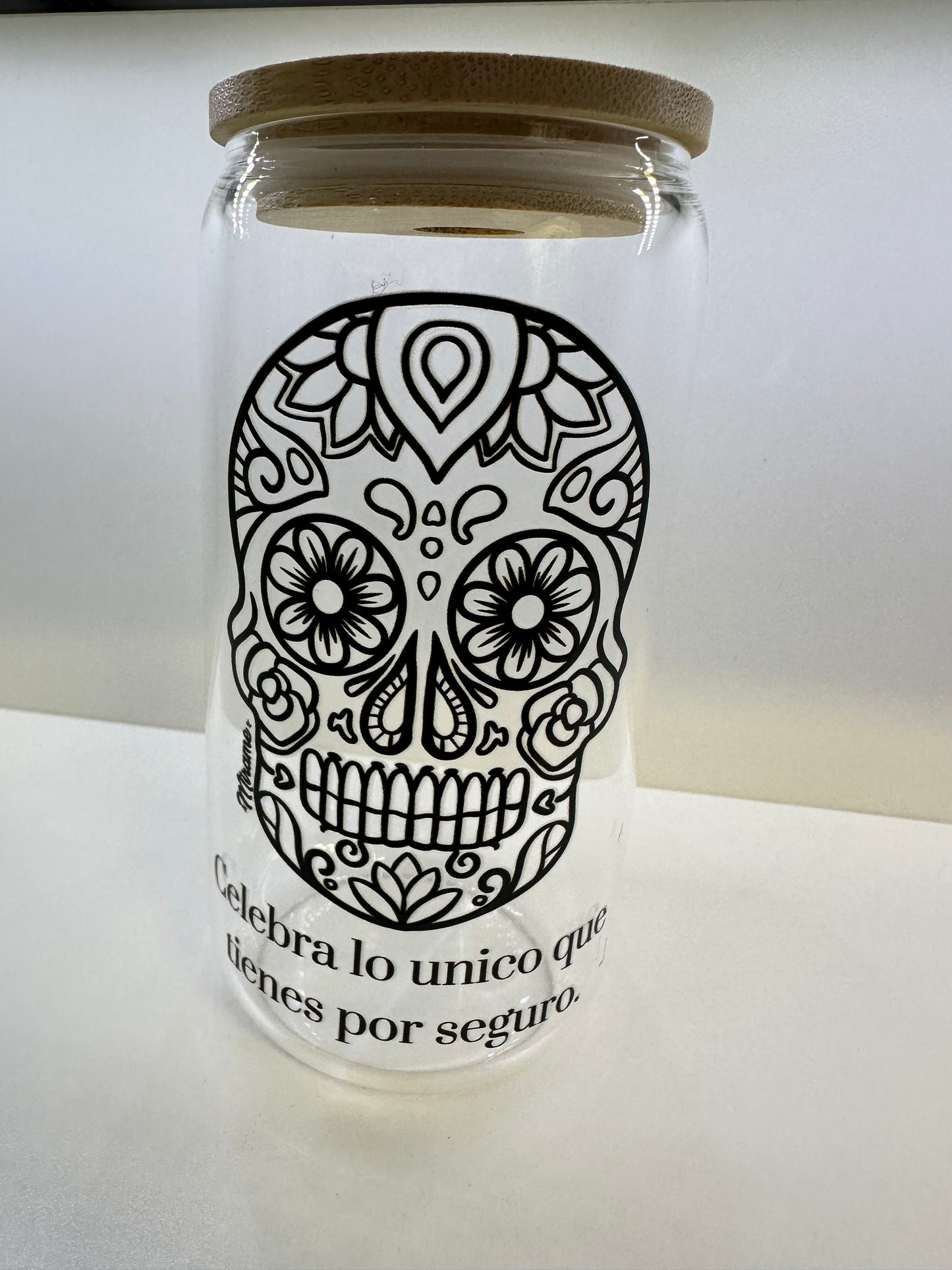 Glass cup with lid and "sugar skull design, Celebra lo unico que tienes por seguro" black